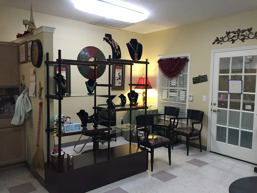 Necklaces on black display busts across glass shelves in the studio